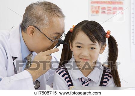 Doctor checking little girl's ear with medical equipment View Large Photo Image Stock Photography - Doctor checking little girl's ear with medical equipment. Fotosearch