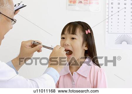 Doctor checking little girl's teeth with medical equipment View Large Photo Image Stock Photo - Doctor checking little girl's teeth with medical equipment. Fotosearch
