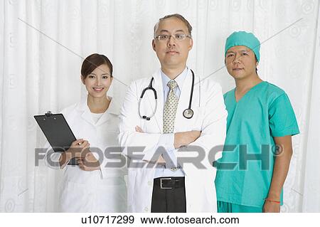Doctor, female doctor and surgeon standing together and looking at the camera View Large Photo Image Stock Photo - Doctor, female doctor and surgeon standing together and looking at the camera. Fotosearch
