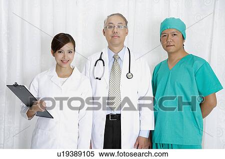 Stock Photography - Doctor, female doctor and surgeon standing and looking at the camera. Fotosearch