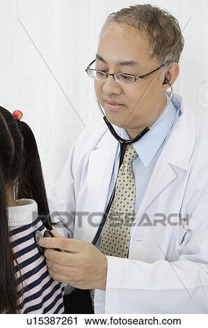 Doctor putting stethoscope on little's back View Large Photo Image Stock Image - Doctor putting stethoscope on little's back. Fotosearch