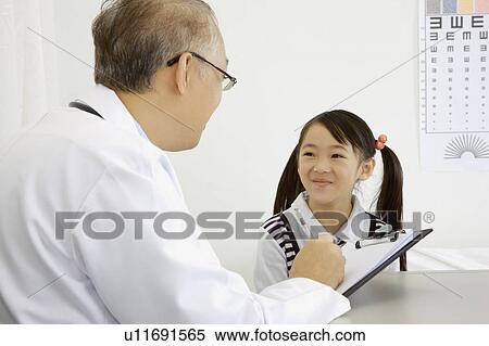 Stock Photography - Doctor talking with a little girl with smile. Fotosearch