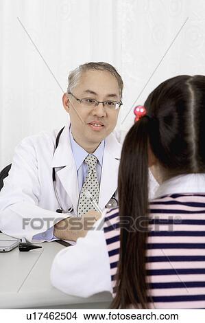 Picture - Doctor talking with little girl. Fotosearch