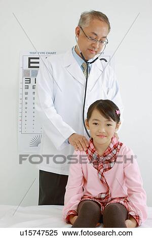 Stock Photography - Doctor using stethoscope to check little girl. Fotosearch