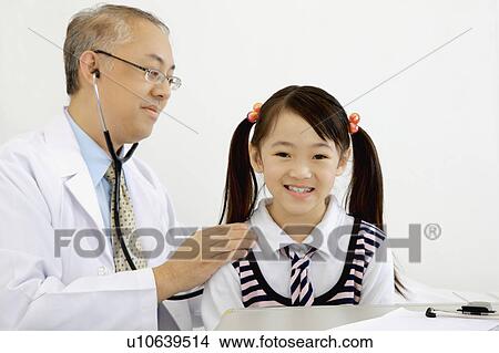 Picture - Doctor using stethoscope to examine little girl. Fotosearch