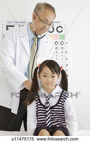 Doctor wearing stethoscope and checking for the little girl View Large Photo Image Stock Photography - Doctor wearing stethoscope and checking for the little girl. Fotosearch