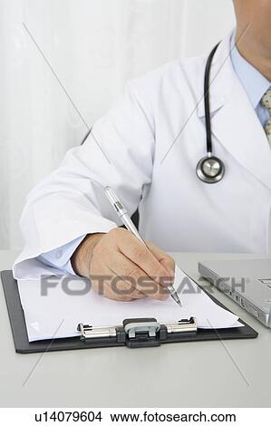 Picture - Doctor writing on the clipboard. Fotosearch