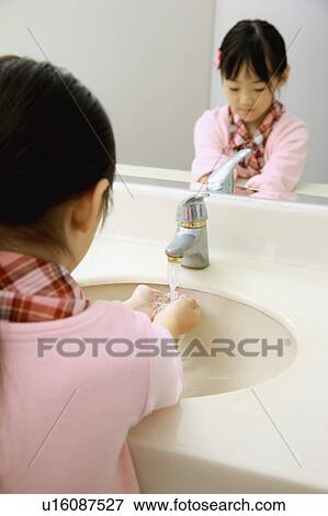 Stock Photo - Little girl washing hands under faucet. Fotosearch