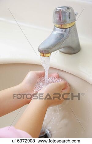 Stock Photo - Little girl's washing hands under faucet. Fotosearch