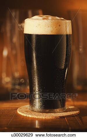 Stock Photo - Ale in beer glass on bar counter. Fotosearch