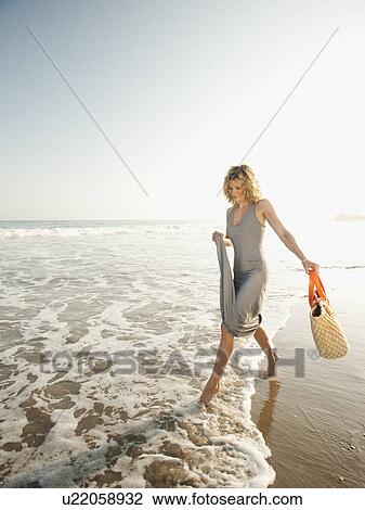 Attractive young woman walking on sandy beach View Large Photo Image Stock Image - Attractive young woman walking on sandy beach. Fotosearch