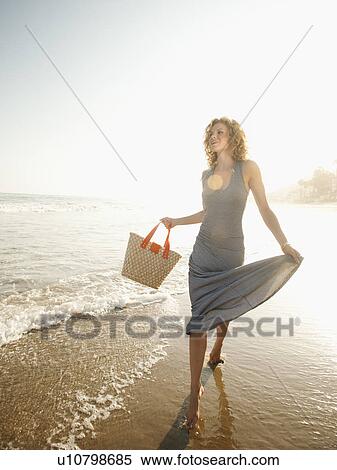 Attractive young woman walking on sandy beach View Large Photo Image Stock Photography - Attractive young woman walking on sandy beach. Fotosearch