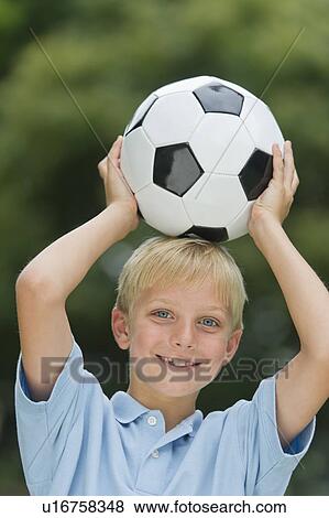 Stock Photo - Boy (10-11) holding soccer ball. Fotosearch