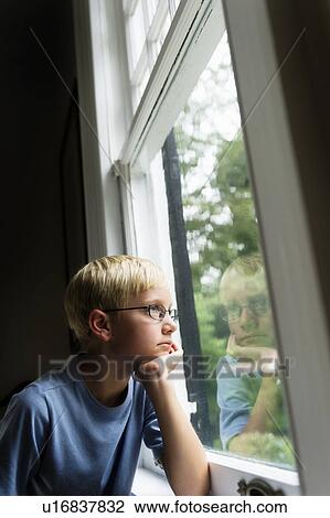 Boy (10-11) looking out window View Large Photo Image Stock Image - Boy (10-11) looking out window. Fotosearch