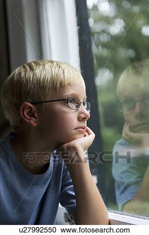 Boy (10-11) looking through window View Large Photo Image Stock Image - Boy (10-11) looking through window. Fotosearch