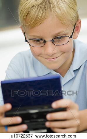 Boy (10-11) playing video game View Large Photo Image Stock Photo - Boy (10-11) playing video game. Fotosearch