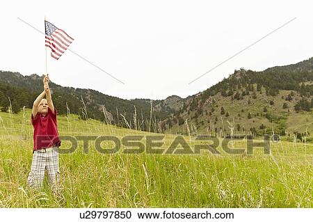 Boy (6-7) waving American flag in meadow View Large Photo Image Stock Image - Boy (6-7) waving American flag in meadow. Fotosearch