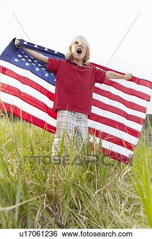 Boy (6-7) waving American flag in meadow View Large Photo Image Stock Photograph - Boy (6-7) waving American flag in meadow. Fotosearch