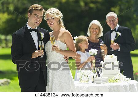 Bride and groom at wedding reception, people in background View Large Photo Image Picture - Bride and groom at wedding reception, people in background. Fotosearch