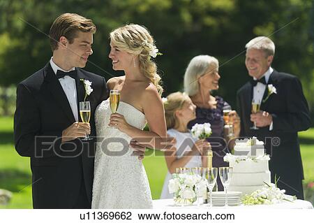 Bride and groom at wedding reception, people in background View Large Photo Image Stock Image - Bride and groom at wedding reception, people in background. Fotosearch
