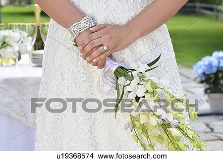 Bride holding wedding bouquet, midsection View Large Photo Image Picture - Bride holding wedding bouquet, midsection. Fotosearch