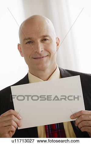 Business man holding blank paper View Large Photo Image Stock Photo - Business man holding blank paper. Fotosearch