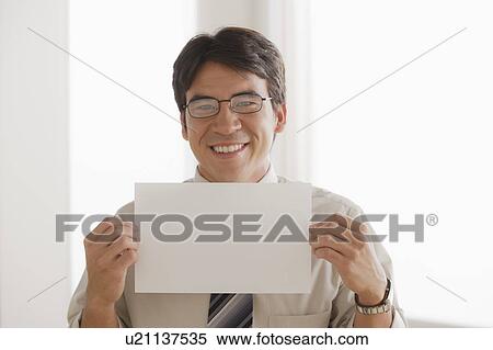 Stock Photography - Business man holding blank paper. Fotosearch