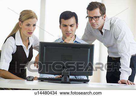 Business team looking at computer View Large Photo Image Picture - Business team looking at computer. Fotosearch