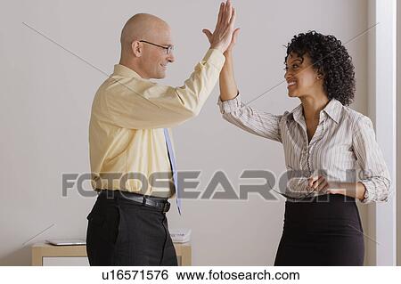 Businessman and businesswoman high fiving View Large Photo Image Stock Photograph - Businessman and businesswoman high fiving. Fotosearch