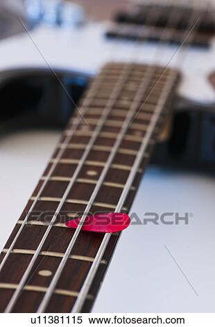 Stock Photography - Close-up of bass guitar with guitar pick. Fotosearch