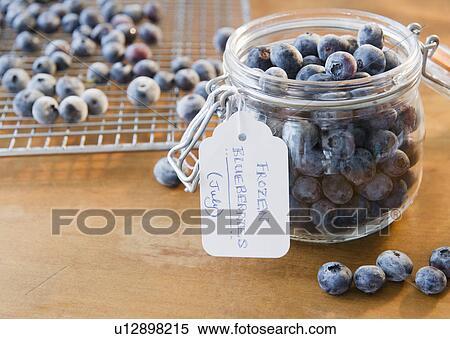 Stock Photography - Close up of frozen blueberries in jar. Fotosearch