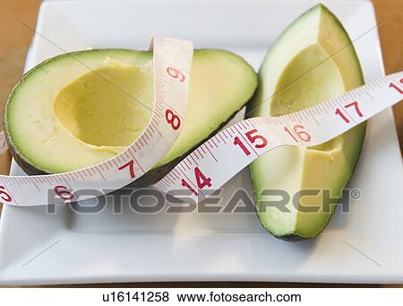 Close up of halves of avocado andMeasuring tape View Large Photo Image Stock Photo - Close up of halves of avocado andMeasuring tape. Fotosearch