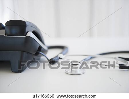 Close up of phone and stethoscope on doctor's desk View Large Photo Image Stock Photograph - Close up of phone and stethoscope on doctor's desk. Fotosearch