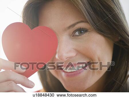 Stock Image - Close up of woman holding red paper heart. Fotosearch