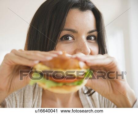Stock Image - Close up of woman showing hamburger. Fotosearch