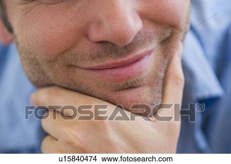 Close-up of young man with hand on chin View Large Photo Image Picture - Close-up of young man with hand on chin. Fotosearch