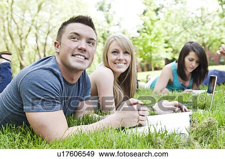 College students relaxing on grass View Large Photo Image Stock Photo - College students relaxing on grass. Fotosearch