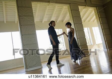Stock Image - Couple dancing in empty room. Fotosearch