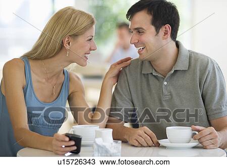 Stock Image - Couple talking in coffee shop. Fotosearch