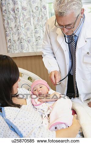 Doctor examining baby girl (2-5 months) held by mother View Large Photo Image Stock Photography - Doctor examining baby girl (2-5 months) held by mother. Fotosearch