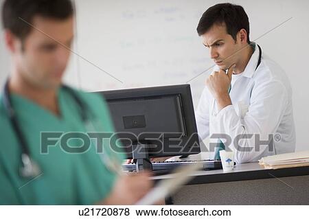 Stock Photo - Doctor looking at computer. Fotosearch