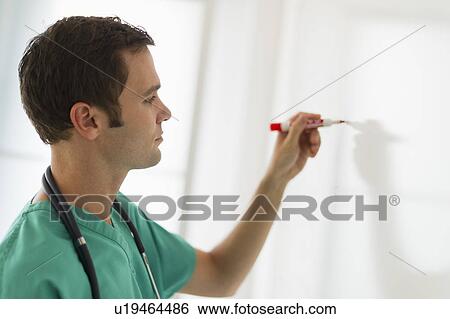 Stock Photograph - Doctor writing on whiteboard. Fotosearch