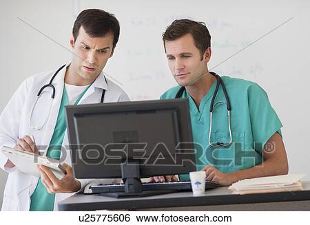 Stock Photograph - Doctors looking at computer. Fotosearch