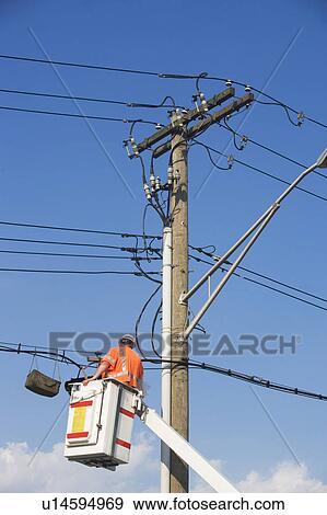 Stock Photo - Electrician working on electricity pole. Fotosearch