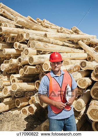 Engineer in front of stack of timber View Large Photo Image Stock Image - Engineer in front of stack of timber. Fotosearch