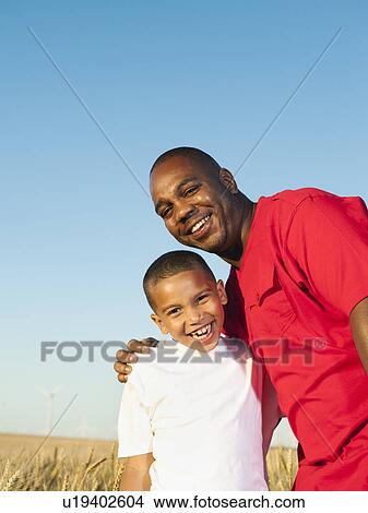 Picture - Father and son (8-9) posing in wheat field. Fotosearch