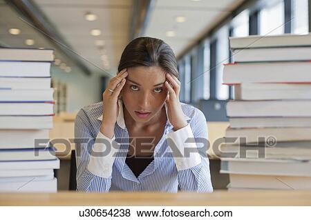 Female student between stacks of books View Large Photo Image Stock Photo - Female student between stacks of books. Fotosearch
