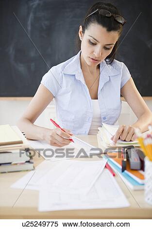 Female teacher writing at desk View Large Photo Image Stock Photography - Female teacher writing at desk. Fotosearch