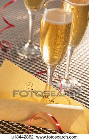 Stock Image - Flutes with champagne and list of resolutions. Fotosearch