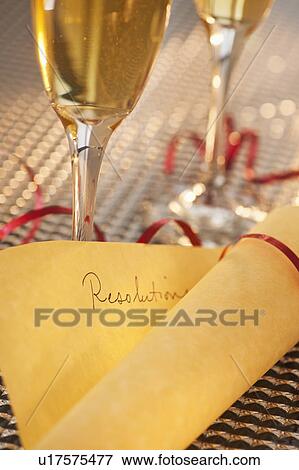 Stock Photo - Flutes with champagne and list of resolutions. Fotosearch